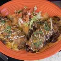 Handmade Spicy Beef Tamales Appetizer · Two shredded beef tamales made with spicy masa topped with chili con carne or queso and garn...
