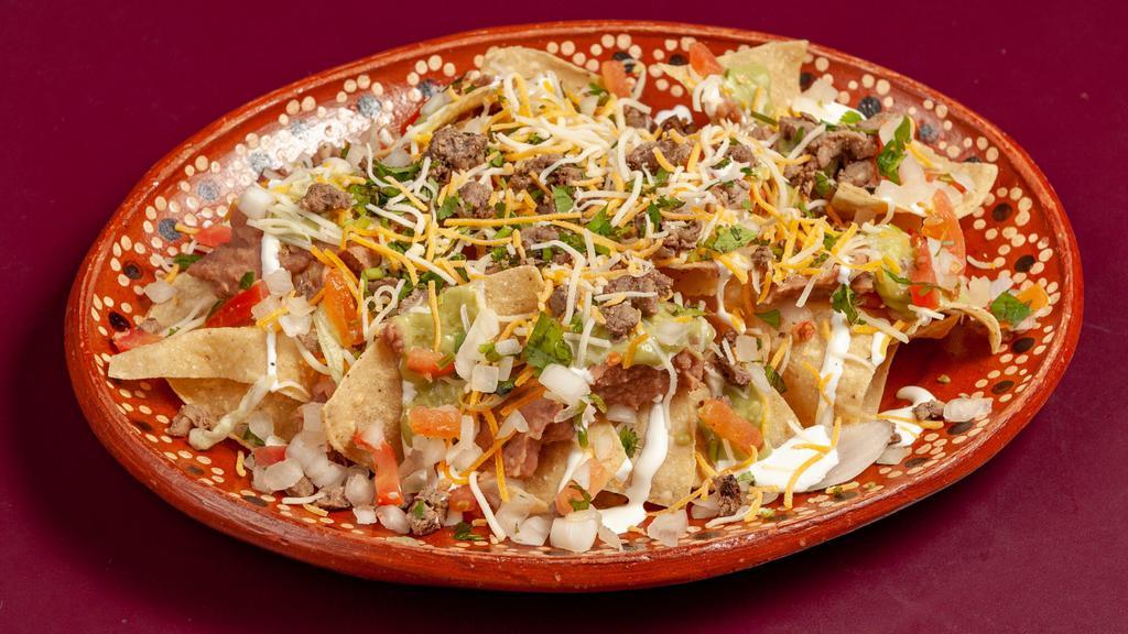 Super Nachos · Tortilla chips topped with asada, beans, guac, pico, sour cream and shredded cheese.