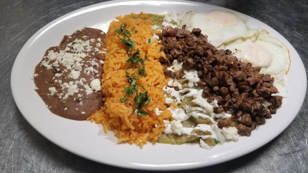Steak Chilaquiles · Traditional chilaquiles with green or red salsa, topped with sour cream, onions and cheese. Two eggs and marinade steak served with Mexican rice and refried beans.