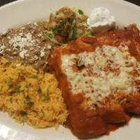 Enchiladas Rojas · Four rolled corn tortillas stuffed with chicken tinga covered in homemade red salsa and melt...
