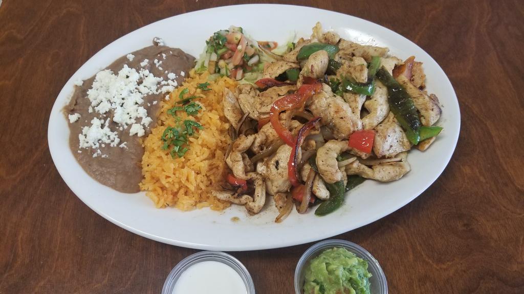 Chicken Fajitas Plate · chicken breast . Sautéed green and red bell peppers and onion.  letucce pico de gallo  guacamole  sour cream side Served with Mexican rice and refried beans and 3 home made tortillas