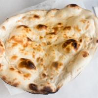 Naan · Leavened bread made of special fine white flour dough, baked in the clay oven.