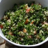 Tabouleh · Finely chopped tomatoes, parsley, and onions. Topped with cracked wheat.