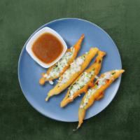 Crisp Chilli Fritters  · Jumbo green chilies sliced, dipped in a spicy batter fried till golden and crispy. Served wi...