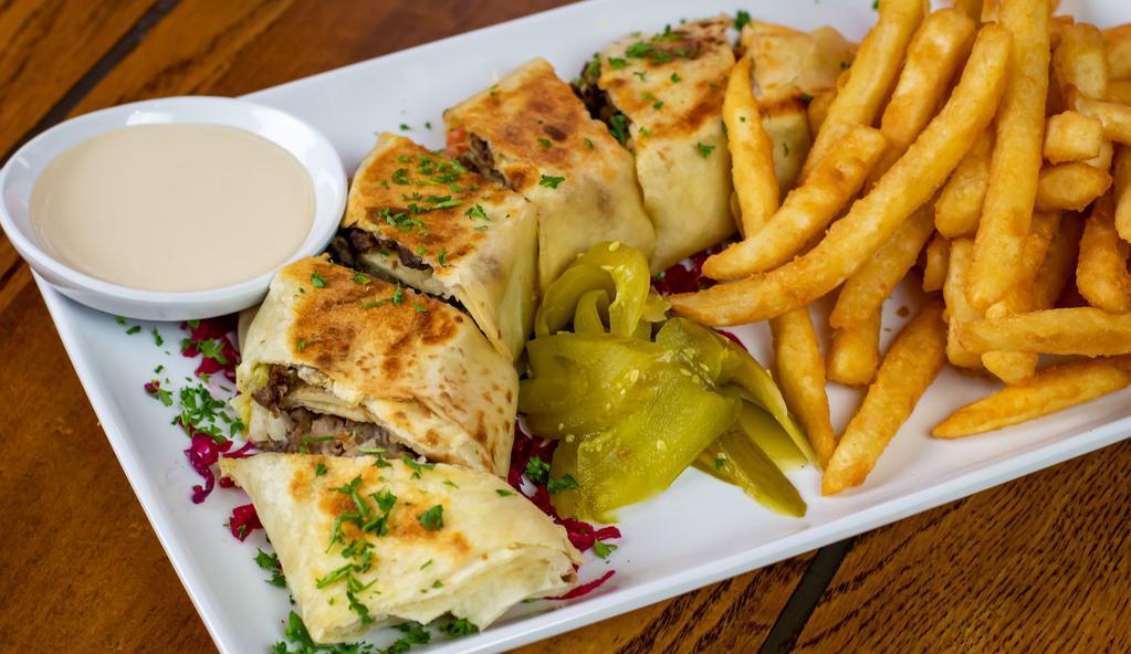 Arabic Beef Shawarma Plate · Thinly sliced cuts of beef with a blend of warm and earthly middle eastern spices, with tahini sauce, onion, and pickles, wrapped in a special bread, served with tahini sauce. Served with Fries.
