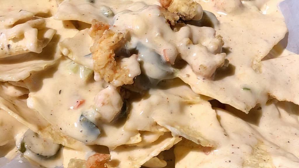 Cajun Nachos · Cheesy queso goodness scattered with jalapeños and jazzed up with Cajun flavors smothering your choice of bed o' chips, regular or Cajun fries. Add popcorn shrimp, crawfish tails, popcorn chicken, and/or sausage for $3 each.