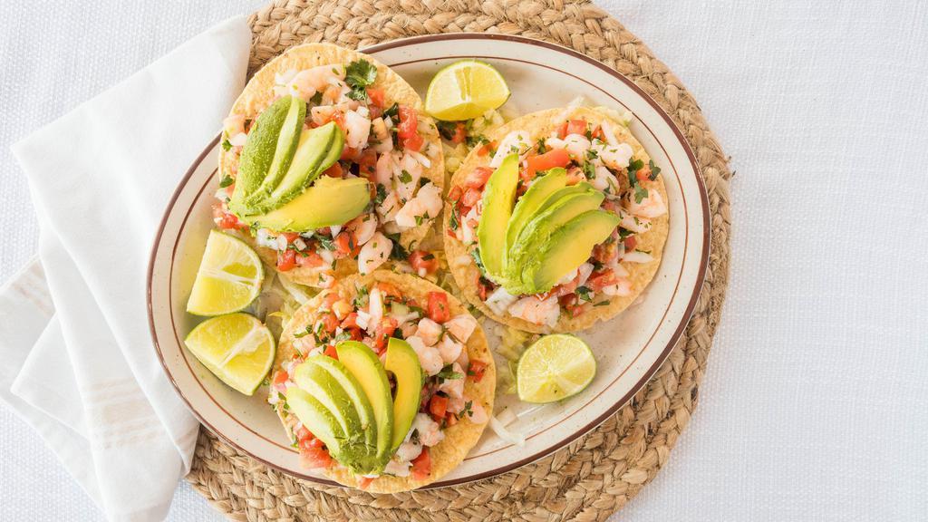 Shrimp Tostadas · Three shrimp tostadas with shrimp cut in pieces, cut onions, tomatoes, cilantro and lime juice.