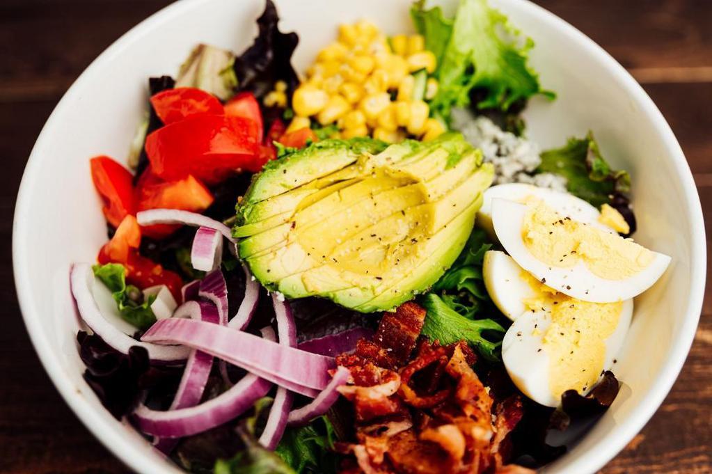 Grilled Chicken Cobb · Mixed greens, corn, avocado, red onion, bacon, tomatoes, egg, bleu cheese crumbles, served with Green Goddess dressing