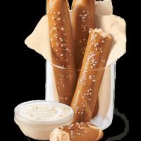Pretzel Sticks With Zesty Queso · Soft pretzel sticks, served hot from the oven, topped with salt and served with warm zesty q...