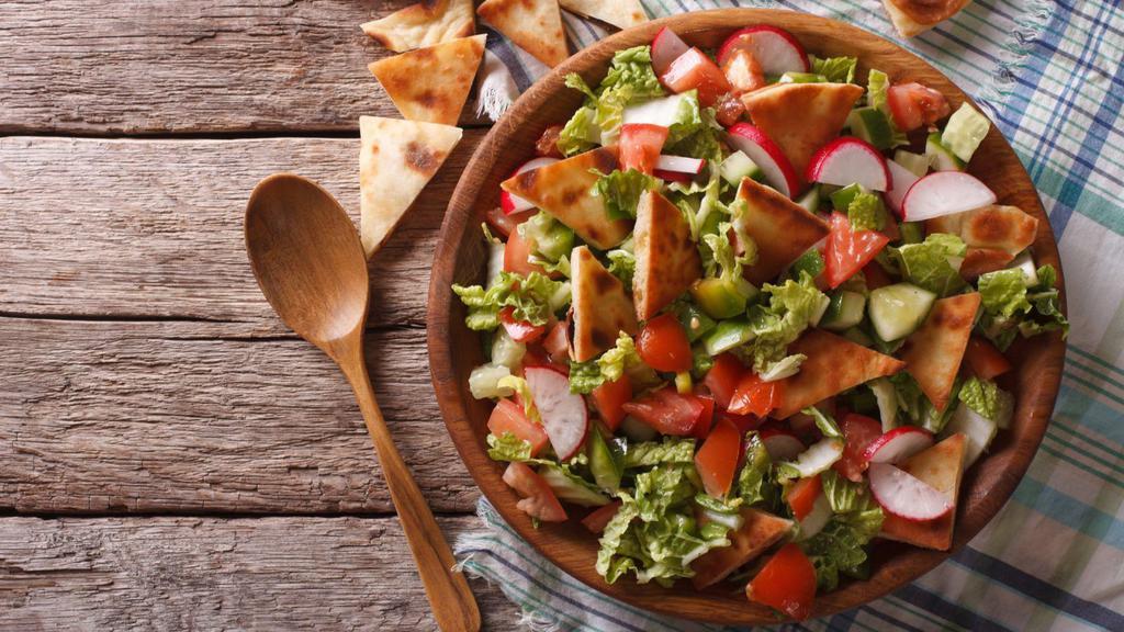 Fattoush Salad · Lavishing salad full of lettuce, tomatoes, green peppers, fried pita bread pieces. Finished with savory parsley, mint, lemon juice, olive oil and salt.