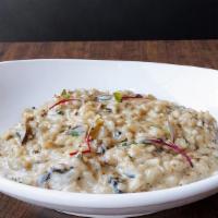 Risotto Ai Funghi · Risotto served with seasonal mushrooms in a parmesan sauce.