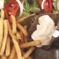Gyros Plate · Piles of sliced gyros meat topped with tzatziki sauce, tomatoes and onion on a pita. Served ...