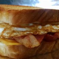 Buenos Dias · 2 pieces fried eggs, American cheese, and bacon on buttered, toasted white bread.