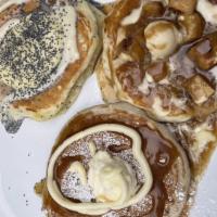 Lemon Poppy Cakes · Three buttermilk poppyseed pancakes topped with house-made lemon curd, lemon cream swirl, po...