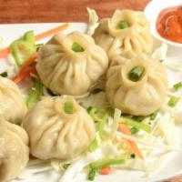 Vegetable Momo · Hand-wrapped steamed veggie dumplings made with potato, cabbage, tofu, cilantro, green peas,...