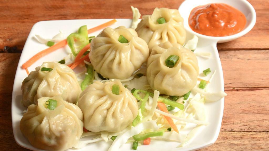 Vegetable Momo · Hand-wrapped steamed veggie dumplings made with potato, cabbage, tofu, cilantro, green peas, and onions.