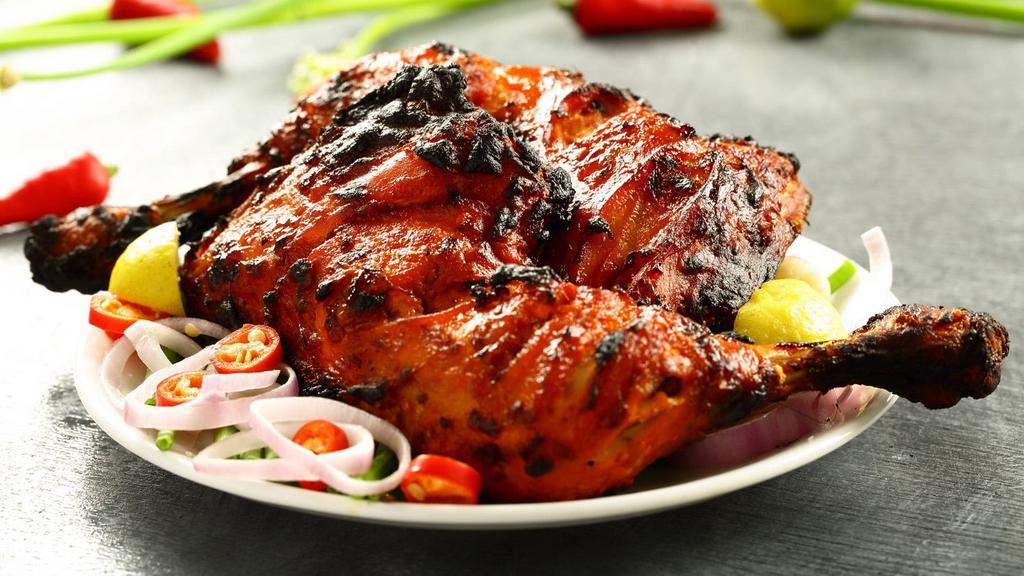 Chicken Tandoori · On the bone succulent chicken marinated in yogurt and fragrant spices, cooked in our hot tandoor and served over a bed of sizzling bell peppers and onions.
