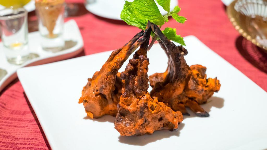 Lamb Tandoori · Tender lamb chops marinated in yogurt and fragrant spices, cooked in our hot tandoor and served over a bed of sizzling bell peppers and onions.
