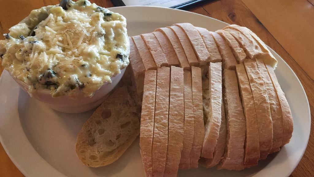 Minnesota Hot Artichoke Dip · Creamy blend of artichoke hearts, wild Rice, spinach and water chestnuts. Served hot with sliced ciabatta bread.