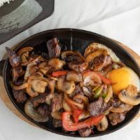 Bo Ne · Vietnamese sizzling beef. Eight oz. tenderloin tossed in a sweet house made sauce then sizzl...