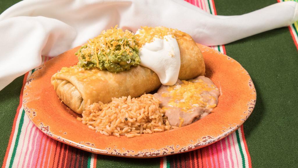 Chimichanga · Popular dish. Crispy, fried tortillas filled with shredded beef and topped with our homemade queso sauce, pico de gallo, guacamole and sour cream. Served with rice and refried beans.