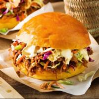 Pulled Pork Sandwich · Smoked pork smothered in BBQ sauce, served with coleslaw and one side dish.