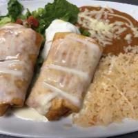 Burrito Deluxe · 2 Burritos filled with refried beans, 1 ground beef, 1 shredded chicken, topped with burrito...