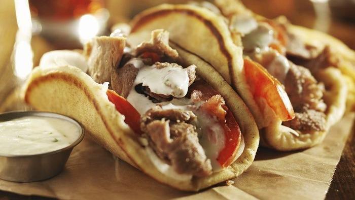 Gyro Sandwich With Fries · Fine sliced Gyros Comes on the top of a Toasted Greek pita with slices of onions, tomato, and delicious Tzatziki sauce.