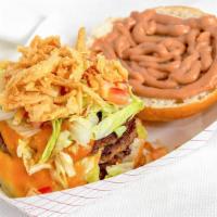 The Mega Burger · Three beef patties layered between slices of different cheeses, topped with onion tanglers, ...