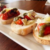 Bruschetta · Oven roasted tomatoes with basil pesto served on oven baked crostini and extra virgin olive ...