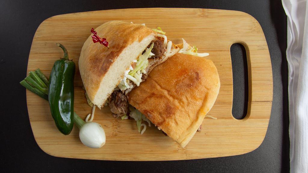 Torta · A Mexican style sandwich with your choice of meat, refried beans, lettuce, tomato, sour cream, and cheese.