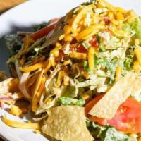 Smashed Taco Salad · Chopped buttercrunch lettuce, vine-ripe tomato, shaved red onion, cheddar cheese, tortilla c...