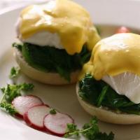 Eggs Benedict Florentine · Two poached eggs atop an English muffin with spinach, mushrooms, and tomatoes. Topped with o...