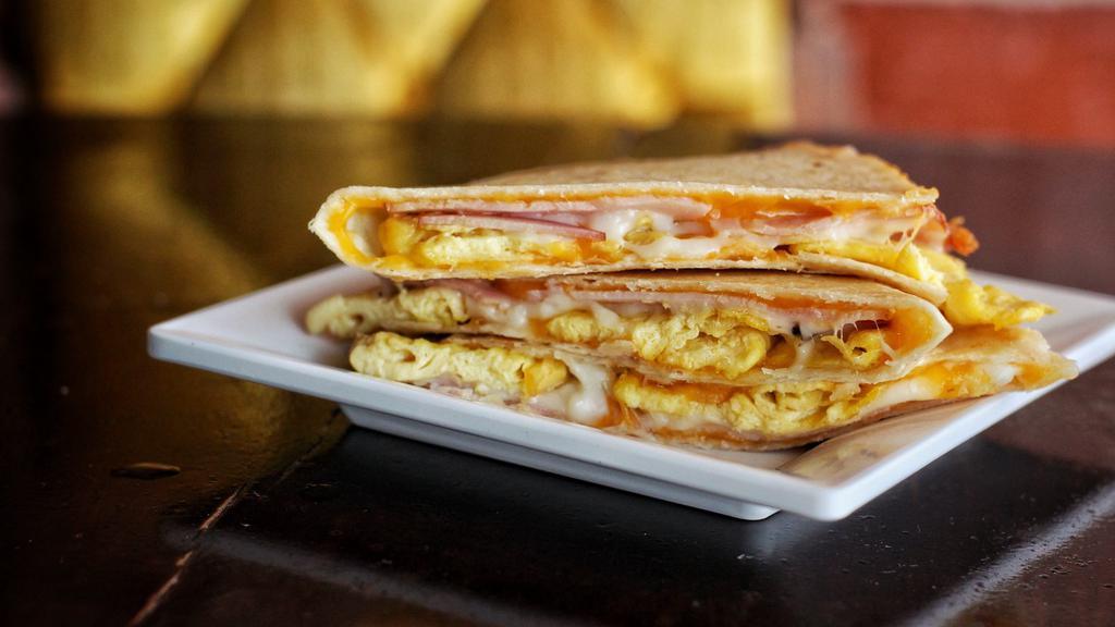 Breakfast Quesadilla · Freshly scrambled eggs, cheddar cheese, and country ham with salsa and sour cream on the side!