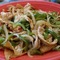 Fajita Nachos · Nacho chips layered with fajita steak or chicken, grilled onions, bell peppers and tomatoes,...