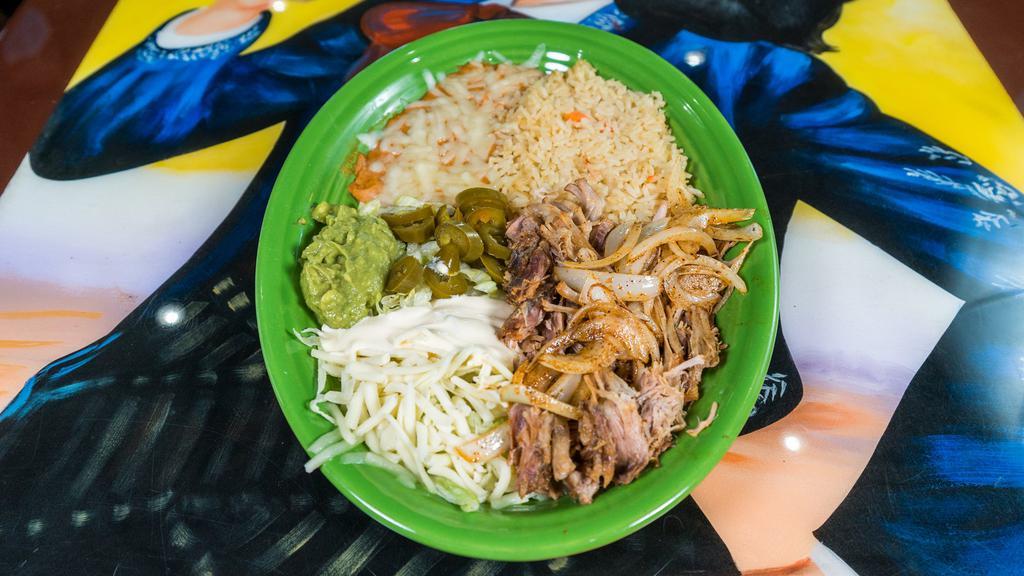 Carnitas Dinner · Tender pork carnitas with grilled onions, served with guacamole salad, pickled jalapeños, rice, beans and tortillas.