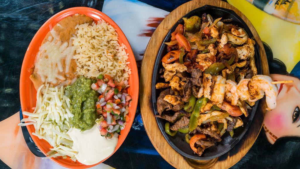 Fajitas Jalisco · Steak, chicken and shrimp, grilled onions, bell peppers and tomatoes. Served with rice, beans, lettuce, guacamole, sour cream, pico de gallo and tortillas.