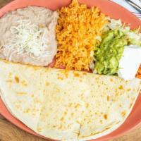 Quesadilla De Queso · Flour tortillas stuffed with cheese and lightly grilled. Served with lettuce, tomatoes, guac...