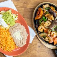 Texana Fajitas · Chicken , steak, and shrimp-
delicately spiced and marinated with onions and bell peppers. S...