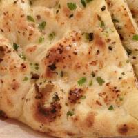 Garlic Naan · traditional hand tossed bread with garlic  freshly bake in a tandoor clay oven