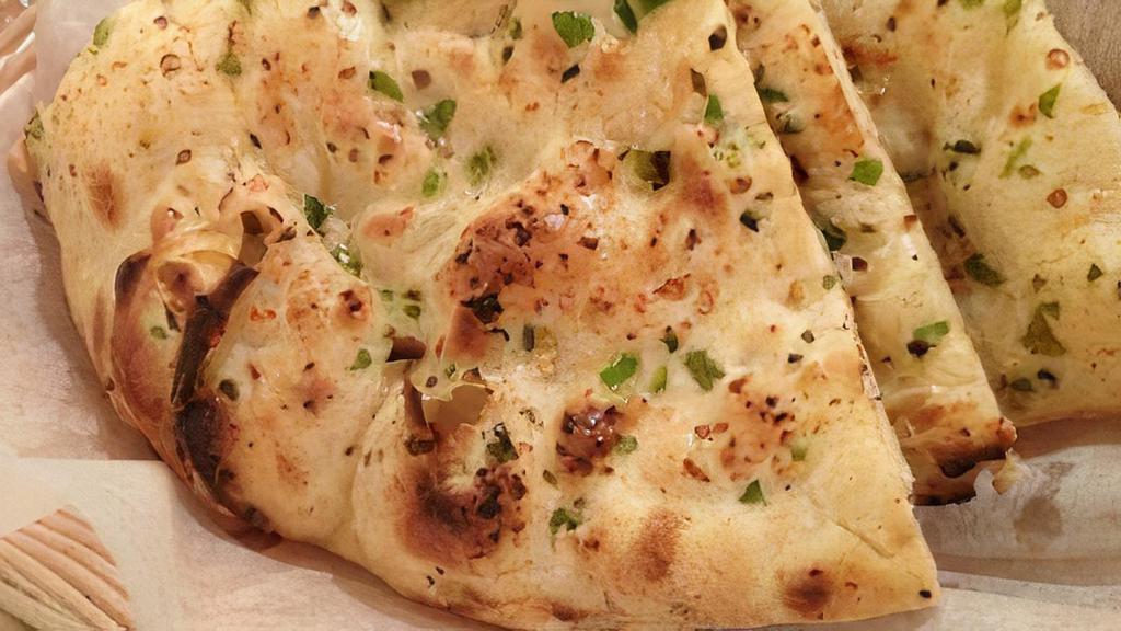 Garlic Naan · traditional hand tossed bread with garlic  freshly bake in a tandoor clay oven