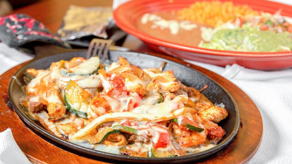 #17. Fajitas Supreme · A combination of steak, chicken, and shrimp with yellow and green squash, onion, tomatoes, topped with cheese sauce.