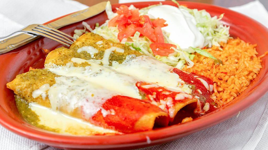 #80. Enchiladas Mi Bandera · Three enchiladas, one beef, one chicken and one cheese cover with cheese, green and ranchera sauce. Served with salad and rice.