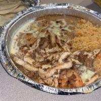 #20. El Michoacano · Grilled shrimp, chorizo and chicken strips topped with cheese sauce. Served with rice, beans...