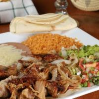 Carnitas Dinner · Braised pork tips topped with grilled onions. Served with guacamole, lettuce, rice, beans, a...
