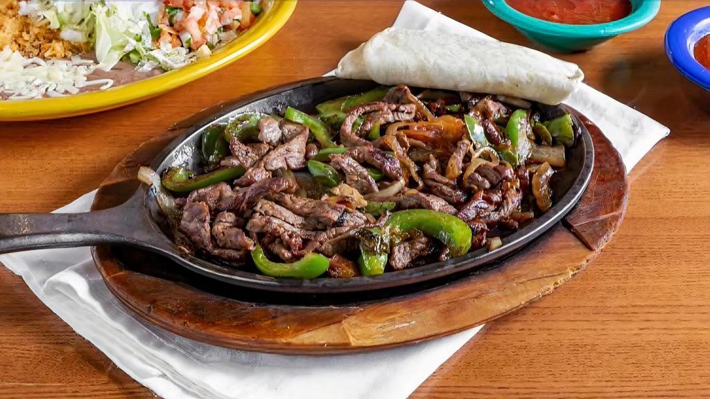 Steak Fajitas · Steak grilled with bell peppers, tomatoes, and onions. Served with rice, beans, guacamole, lettuce, sour cream, pico de gallo, & tortillas.