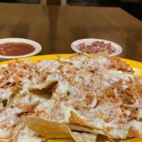 Chicken Nachos · A bed of crispy tortilla chips topped with melted cheese and shredded chicken.