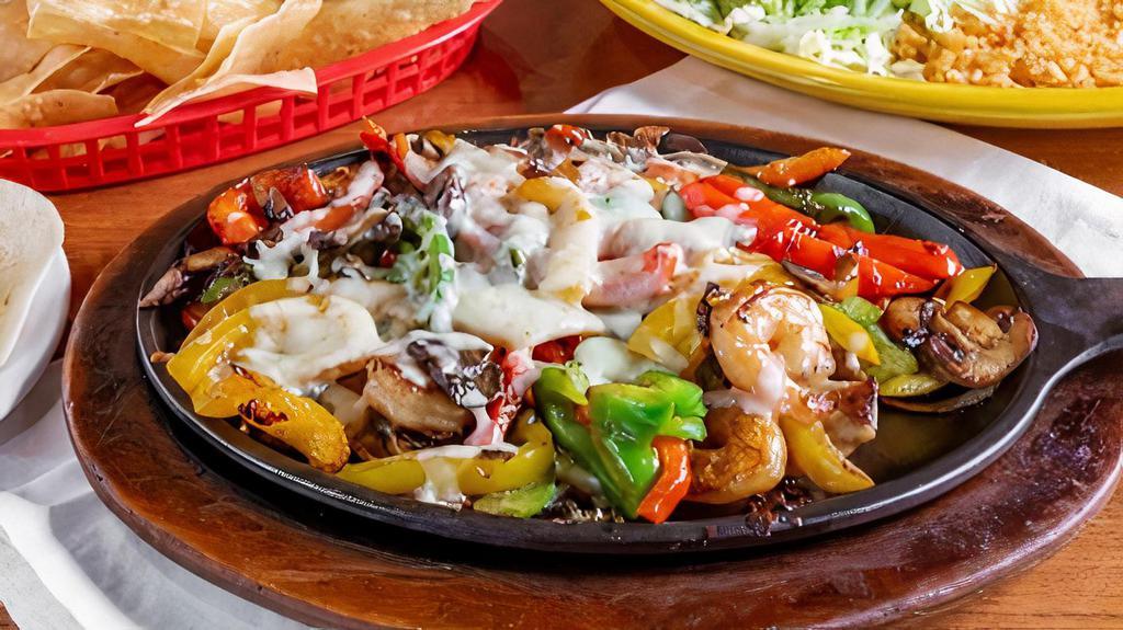 Pollo Fundido · Grilled Chicken & Shrimp grilled w/ mushrooms & peppers.  Topped w/ melted white cheese. Served w/ rice, beans, guacamole, lettuce, sour cream, pico de gallo, & tortillas.
