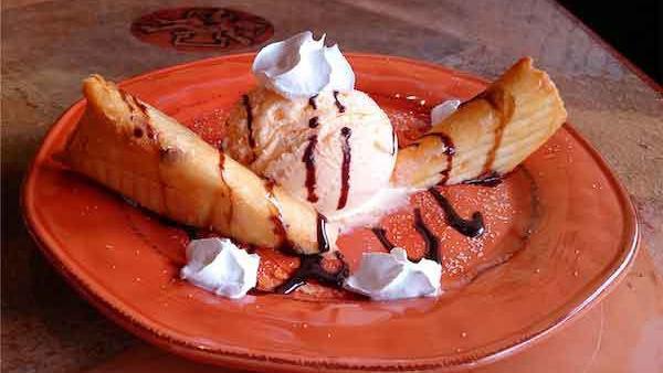 Mexican Cheesecake · Flutes of flour tortillas stuffed with cheesecake filling and topped with honey and cinnamon. Topped with a giant scoop of vanilla ice cream and drizzled with chocolate syrup.