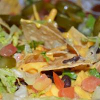 Nachos · Tortilla chips topped with cheddar cheese, jalapeno cheese sauce, fresh tomatoes, black bean...